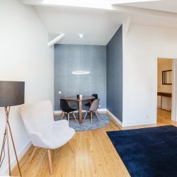 Modern living room in small apartment with white walls and light wooden floor